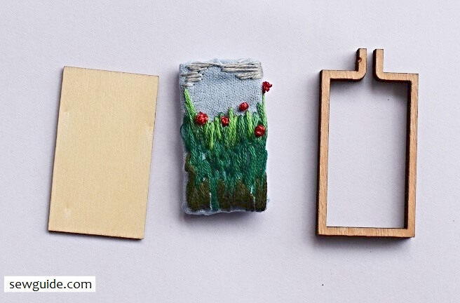 embroidered fabric gathered around the base, the frame for the pendant ready to be assembled