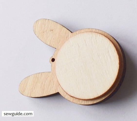 The embroidered fabric base inserted inside the pendant and the back kept in place