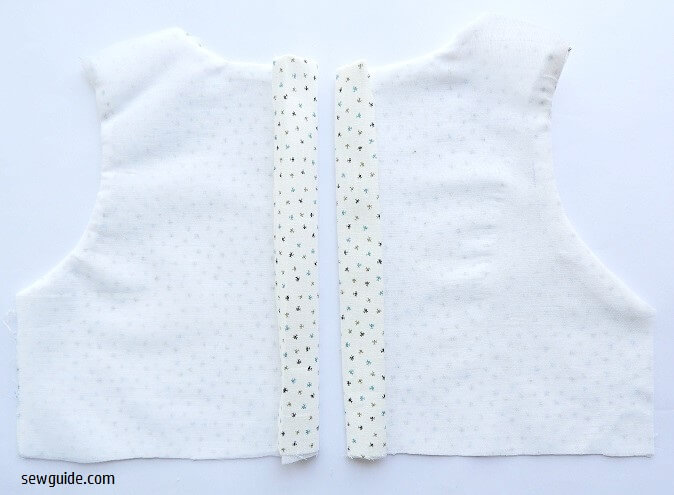 Turn the open edges at the center to the back and sew as placets