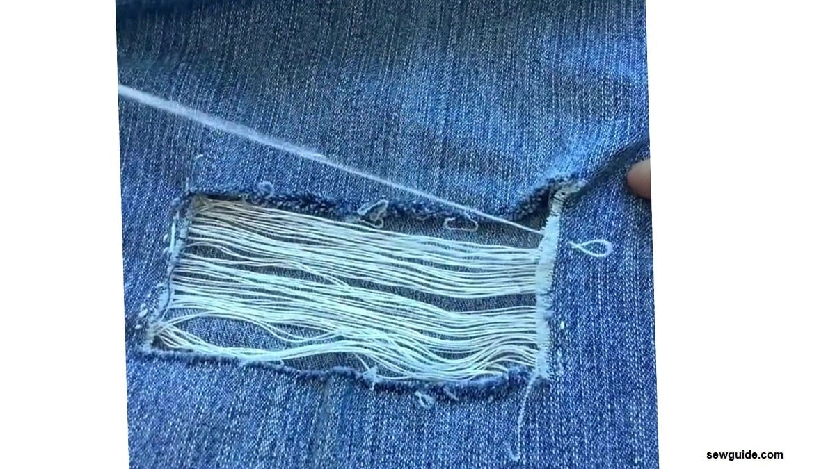 jeans hole filled with white thread