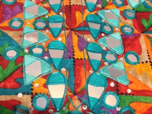 Satin stitch is used over the triangular shishas or mirrors