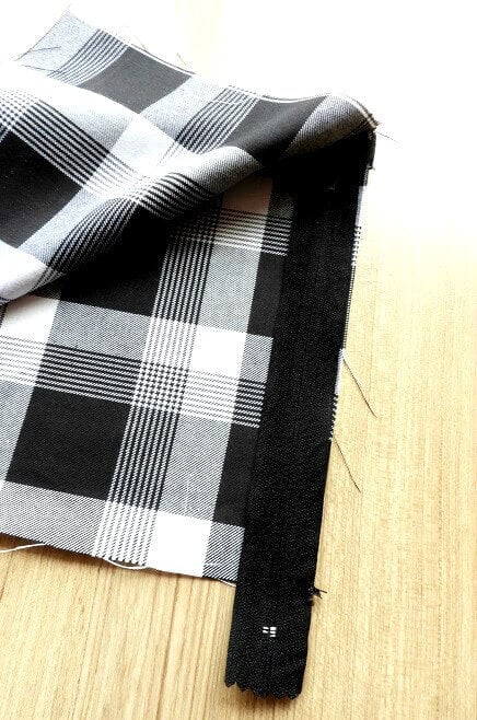 Zipper kept inside the lining of the pleated skirt