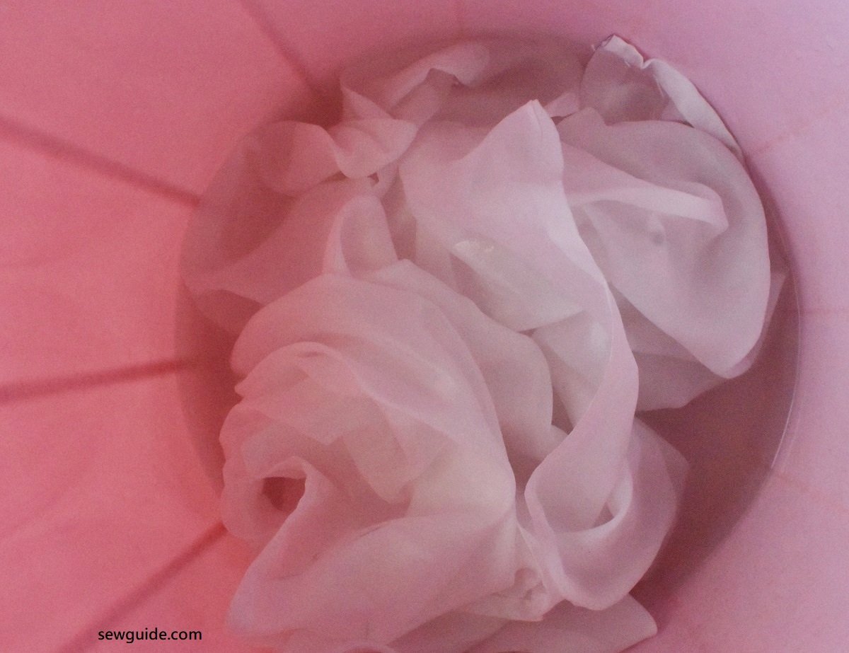 wash off all sizing from silk fabric before dyeing in a bucket full of water and some detergent.