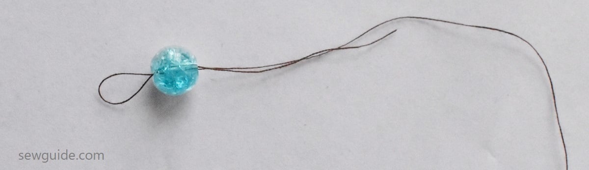 Insert the looped thread through the bead